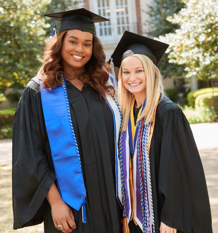 Two students in graduation cap and gown